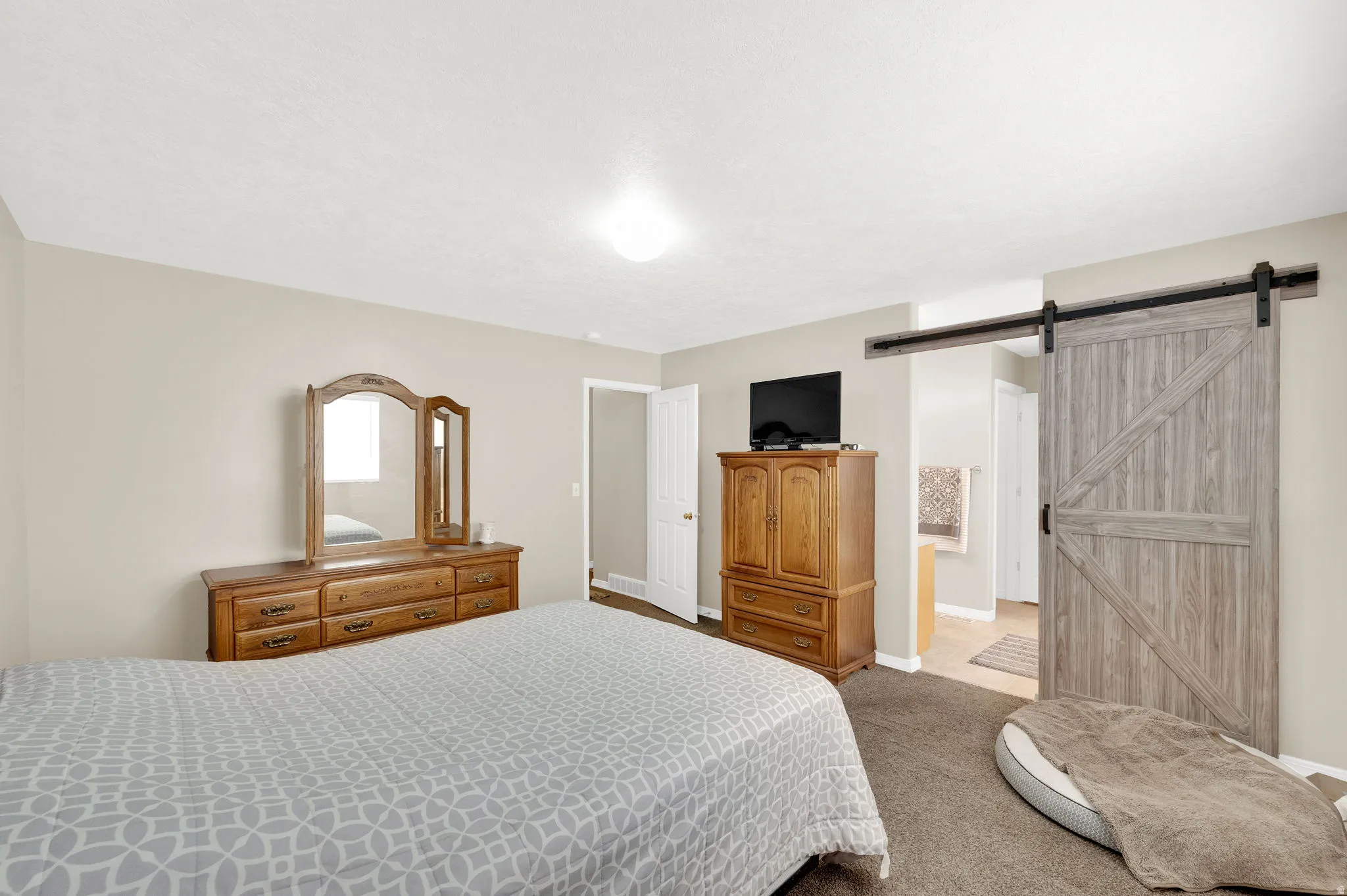 Spacious room featuring neutral paint tones and textured carpet flooring