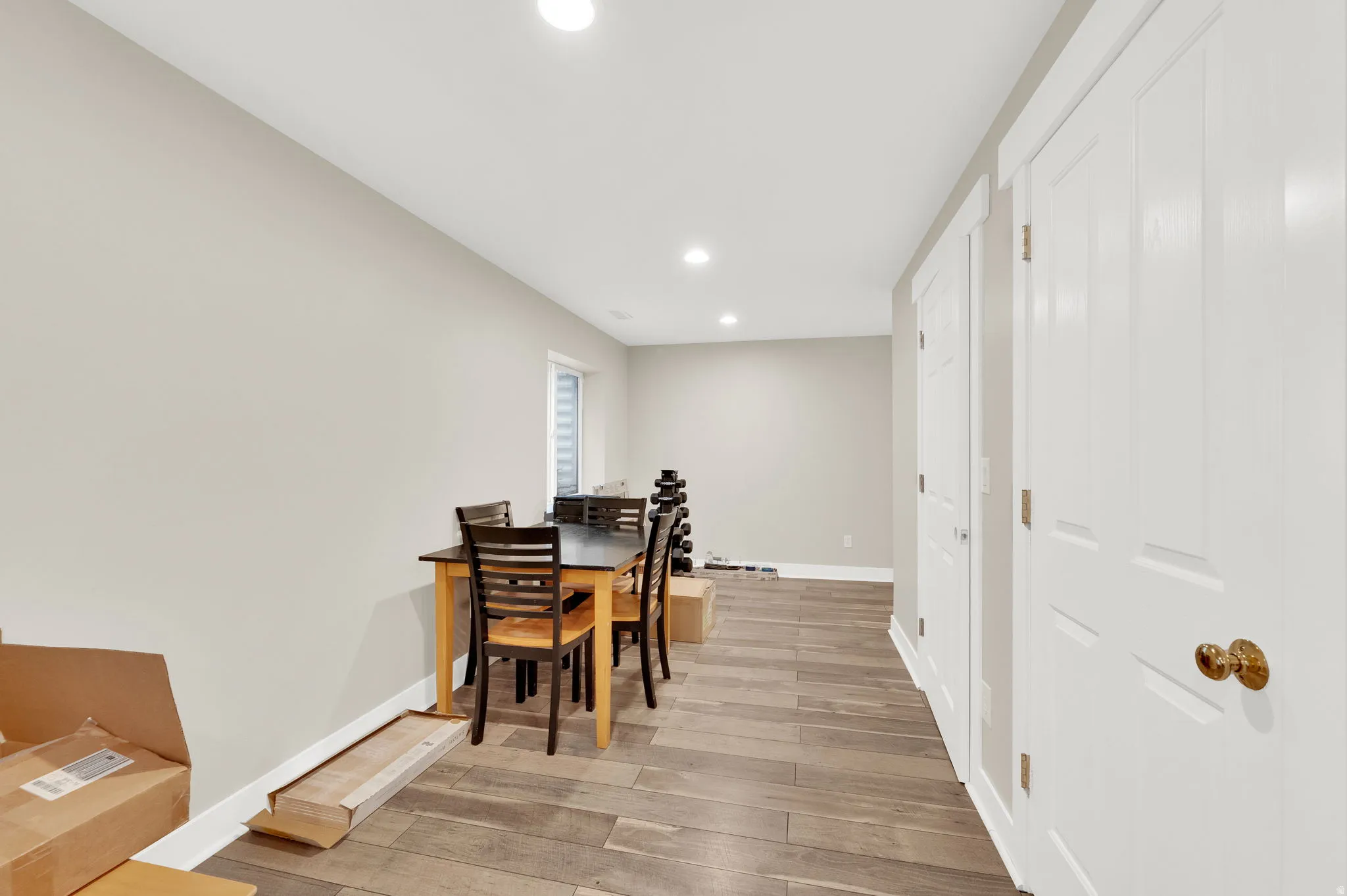 Spacious room featuring wood-finish flooring, recessed lighting, and a neutral wall palette
