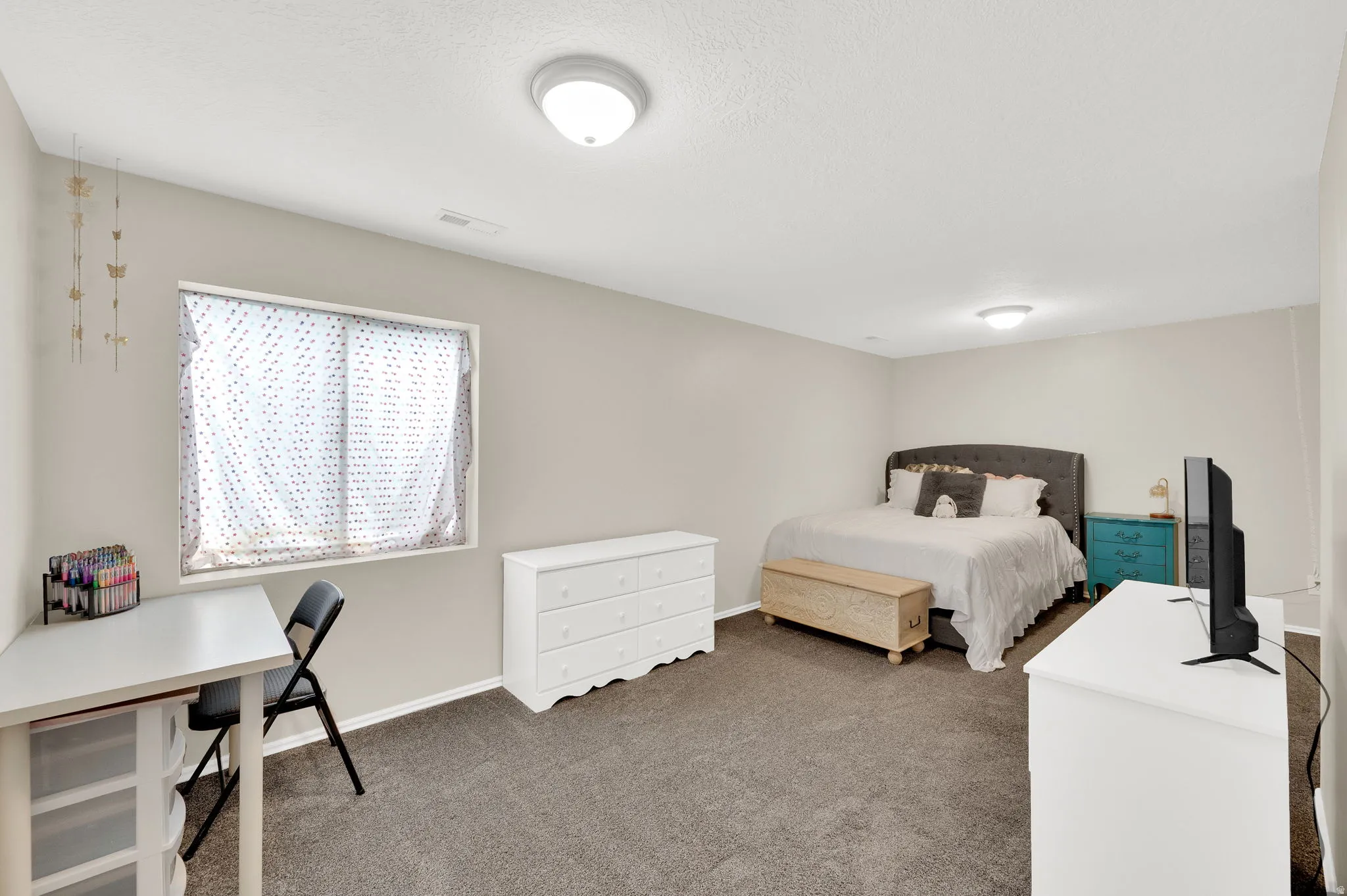 Neutral wall paint complements the gray carpeting