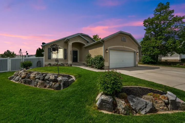 Stucco exterior with an arched entryway and an attached garage