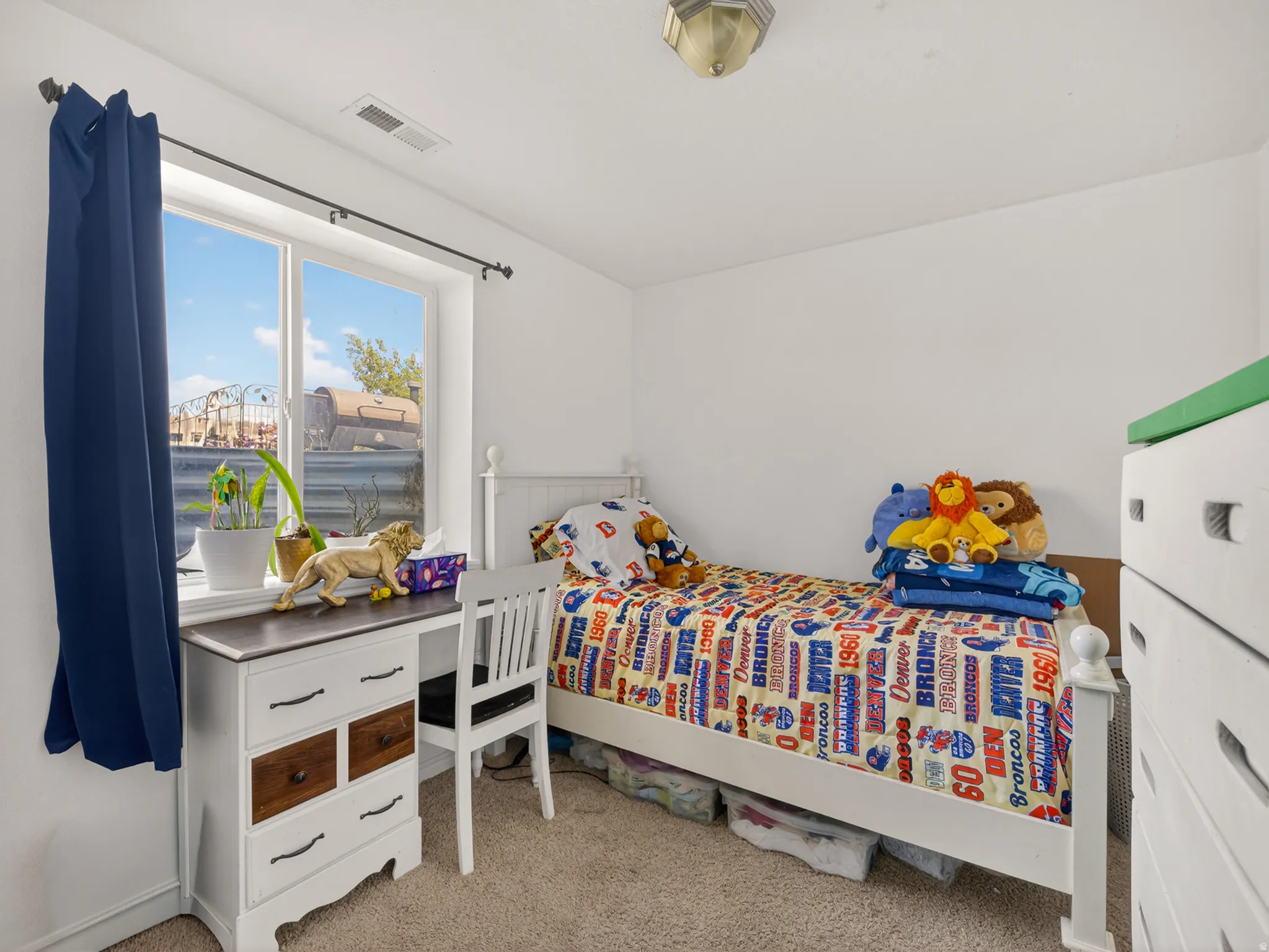 Bright bedroom featuring a large window, neutral wall paint, and a built-in ceiling light fixture