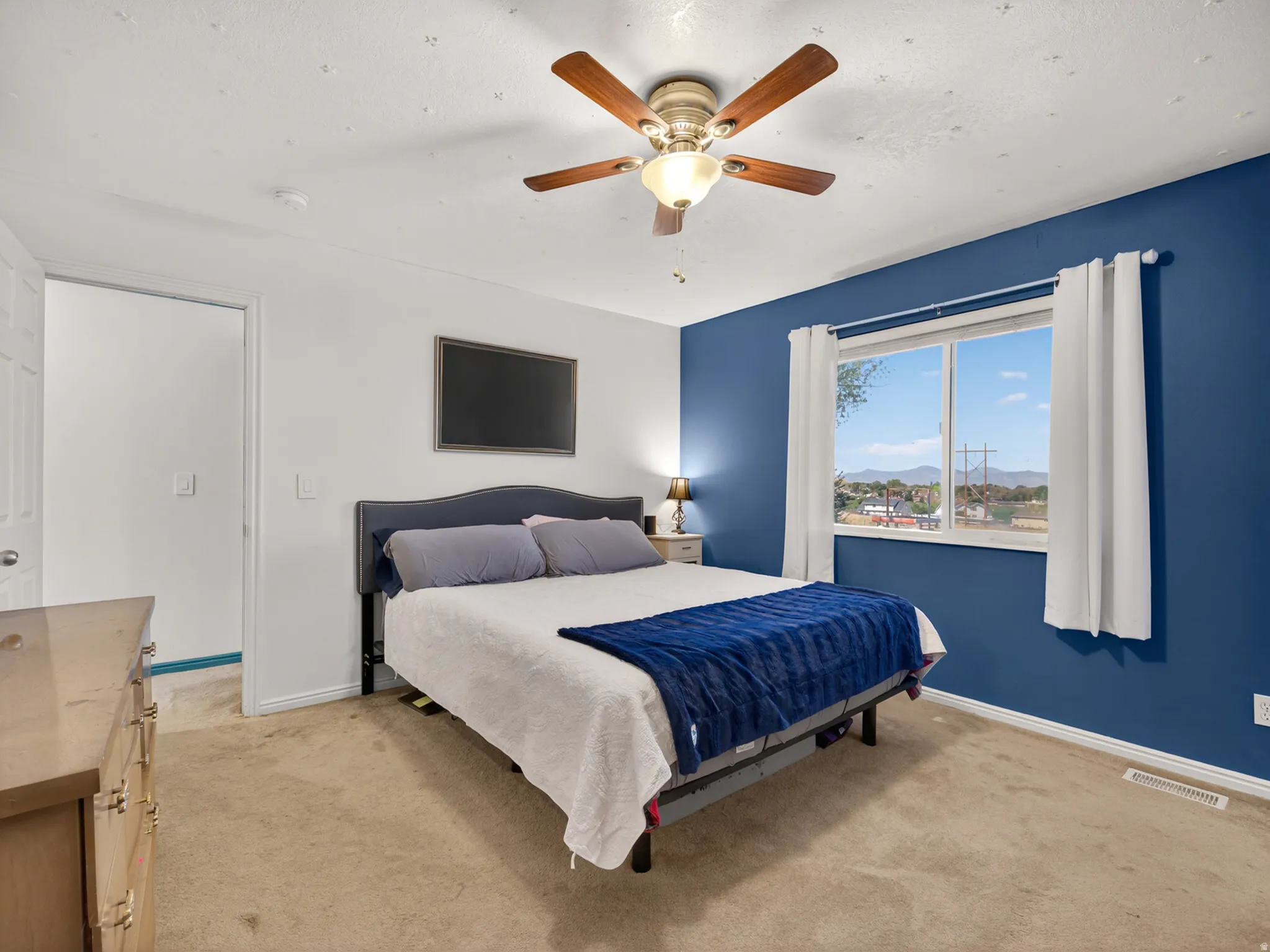Primary bedroom featuring carpet flooring and a ceiling fan with light fixture