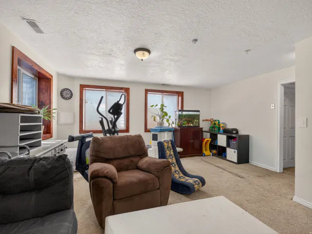 Basement family room with multiple windows featuring wood-finish trim