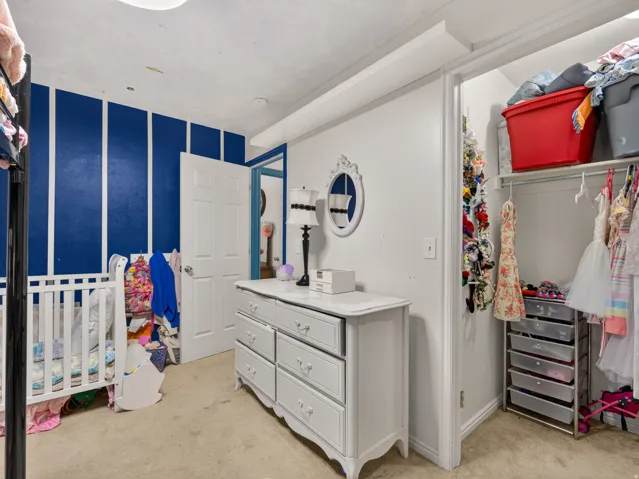 Secondary main floor bedroom featuring accent wall