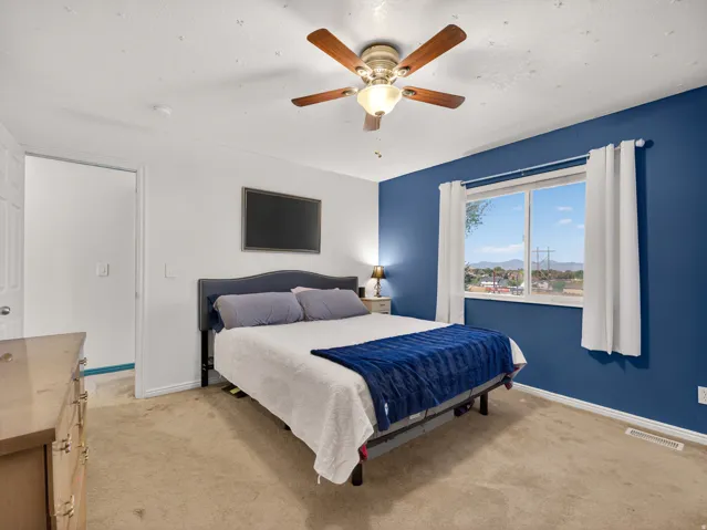 Primary bedroom featuring carpet flooring and a ceiling fan with light fixture