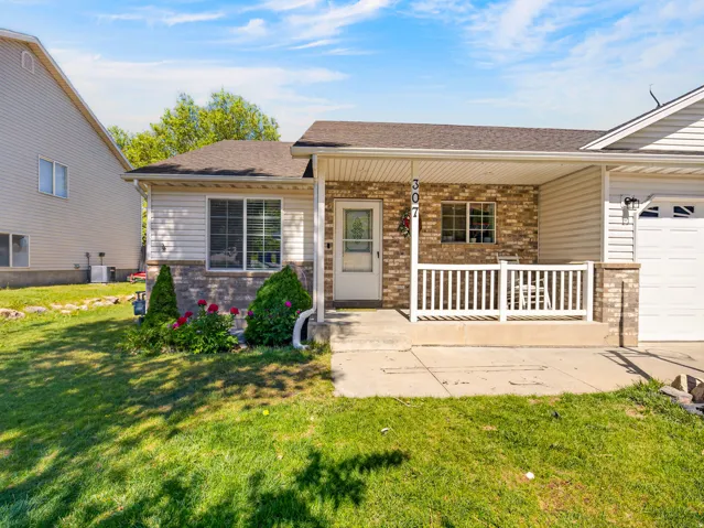 Twin home featuring brick accents, light colored siding, and an attached garage