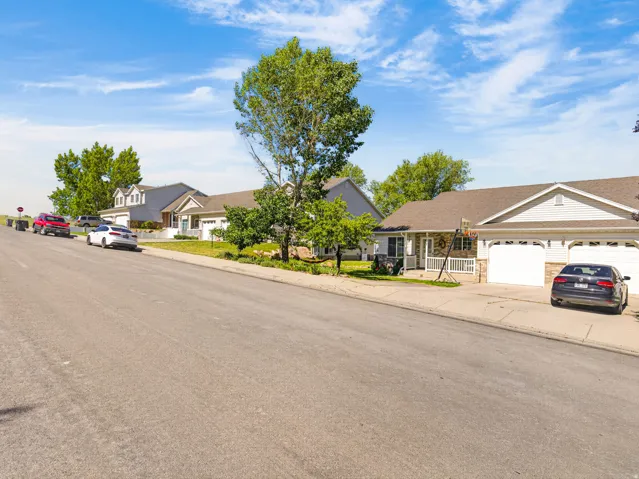 Ranch-style exterior with white siding, a covered porch, and a two-car garage