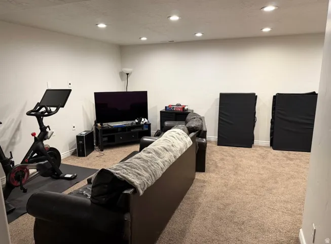 Spacious carpeted room featuring recessed lighting and white baseboards