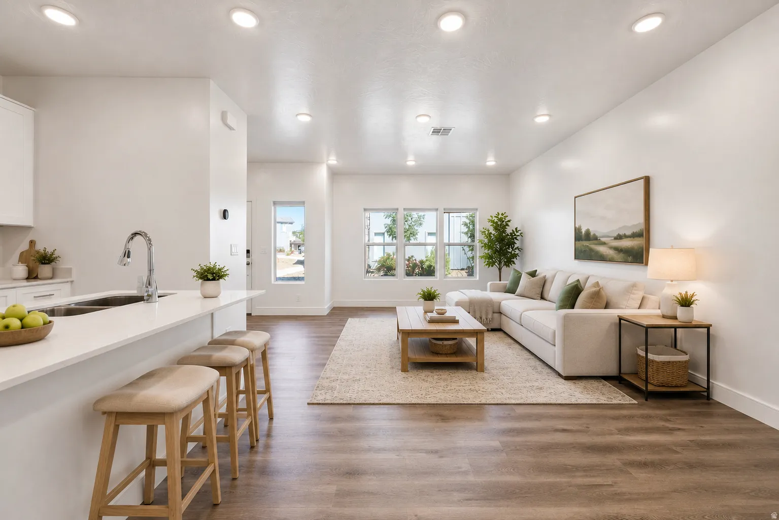 Open-concept living area with recessed lighting, wood-finish flooring, and multiple windows