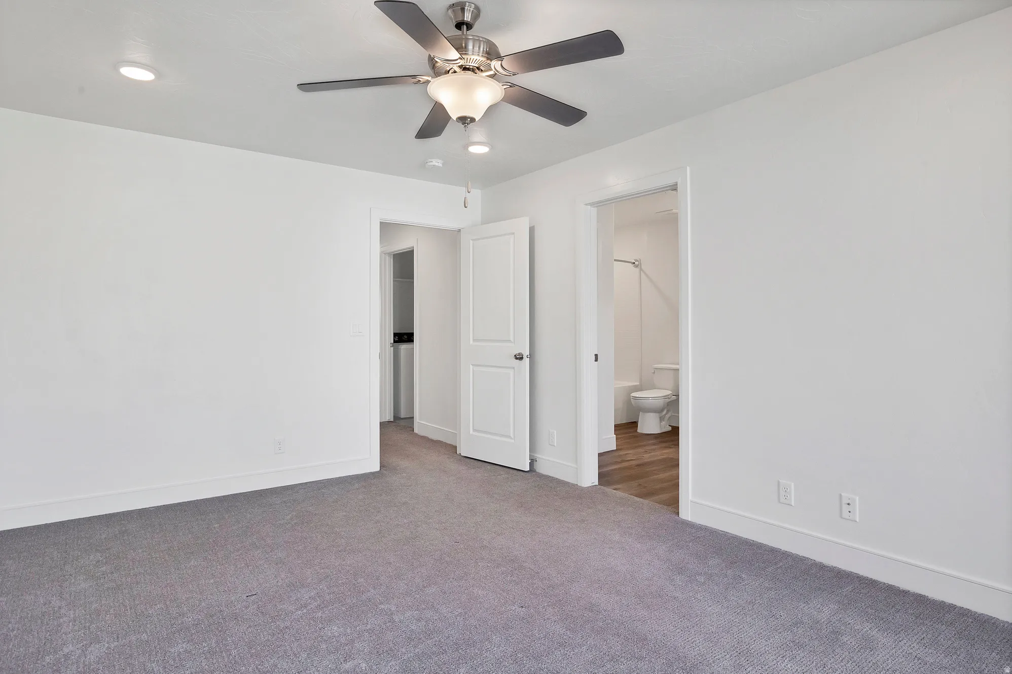 Bedroom featuring a ceiling fan with integrated lighting, recessed ceiling lights, and grey carpeting