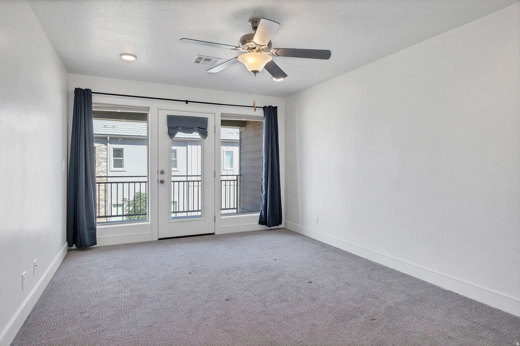 Bedroom with light gray carpeting and white walls
