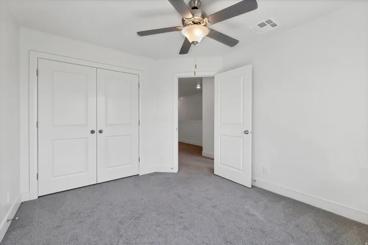 Spacious room featuring plush gray carpeting and white walls