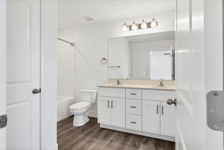 Bathroom featuring a dual vanity with white cabinetry, light-toned countertop, and undermount sinks