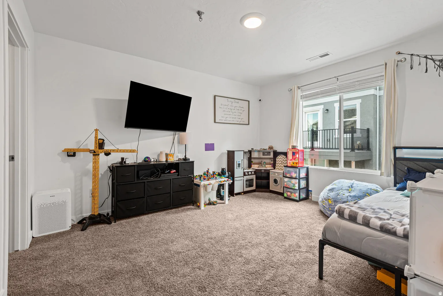 Carpeted room with a large window featuring a sliding glass door