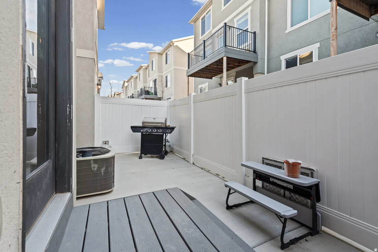 Private outdoor patio featuring a composite deck and concrete paving