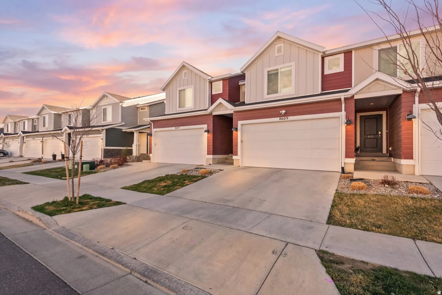 Townhome exterior featuring red siding and white trim