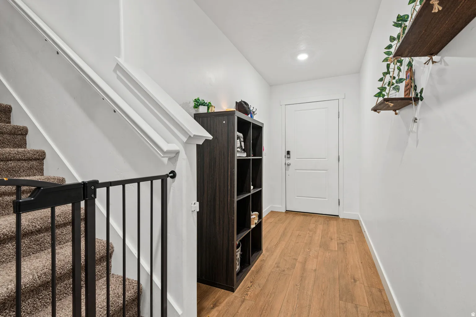 Entryway featuring wood-finish flooring, a white paneled door, and recessed lighting