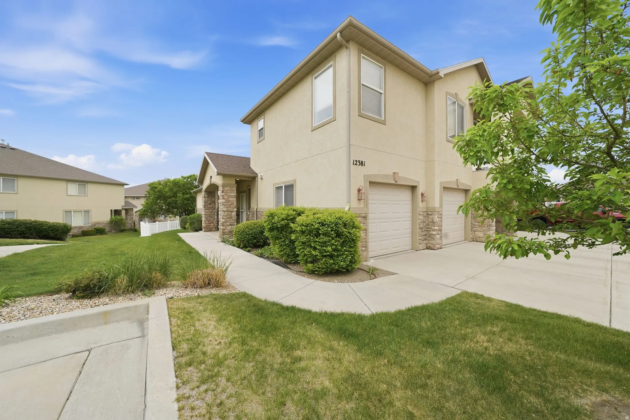 Stucco exterior with stone accents and dual garage doors