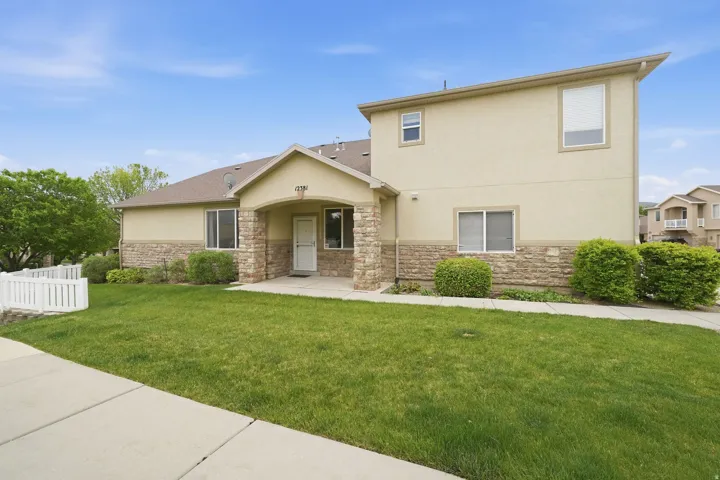 Exterior stucco and stone veneer facade featuring a covered entry