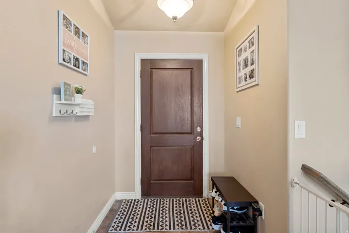 Entryway featuring a rich wood-paneled door, recessed lighting, and neutral wall tones
