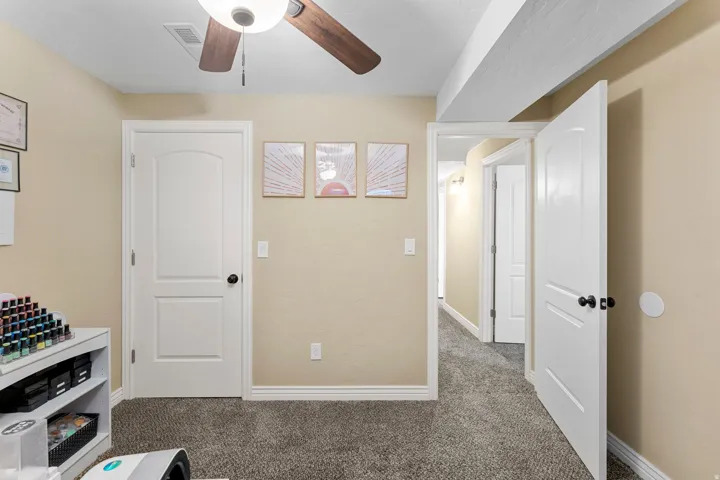 Room featuring textured beige walls and dark gray carpet flooring