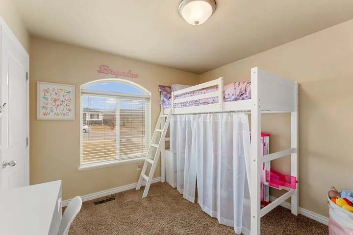 Room featuring an arched window with blinds, carpeted flooring, and a flush-mount ceiling light fixture