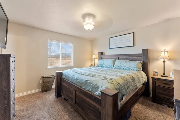 Carpeted room featuring a window with horizontal blinds, a ceiling-mounted light fixture, and neutral-toned walls