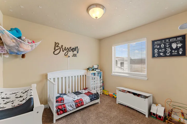 Carpeted room with a ceiling-mounted light fixture, a window with blinds, and light-colored walls