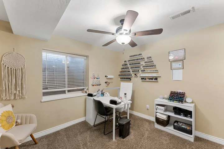 Carpeted room featuring a ceiling fan with integrated lighting, a window with horizontal blinds, and baseboard molding
