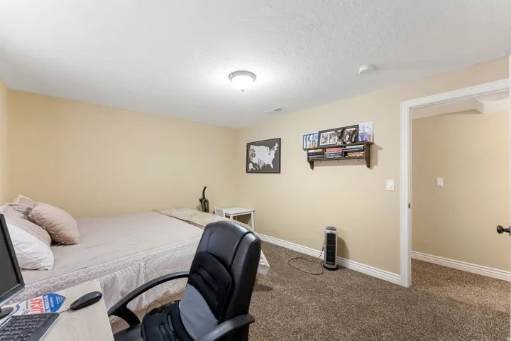 Room featuring neutral wall tones, textured ceiling, and a built-in wall shelf