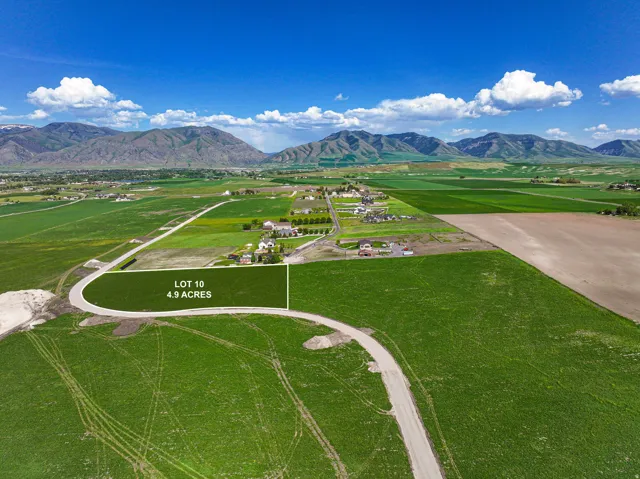 Expansive 4.9-acre parcel featuring green fields and mountain scenery
