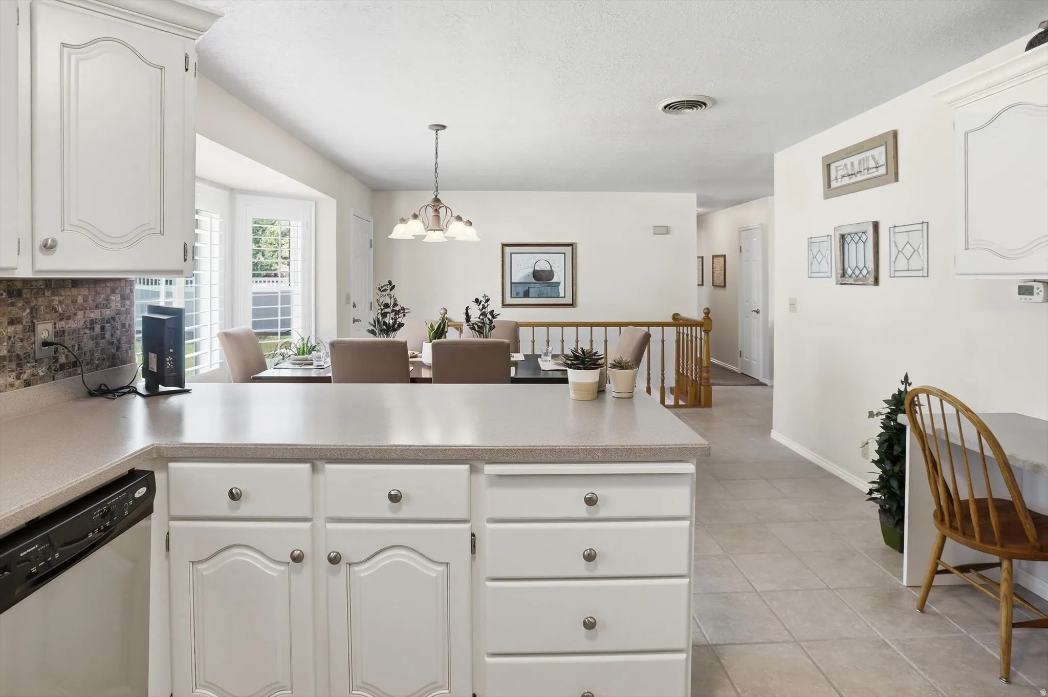 Kitchen featuring white cabinetry, light-colored countertops, and a tiled backsplash