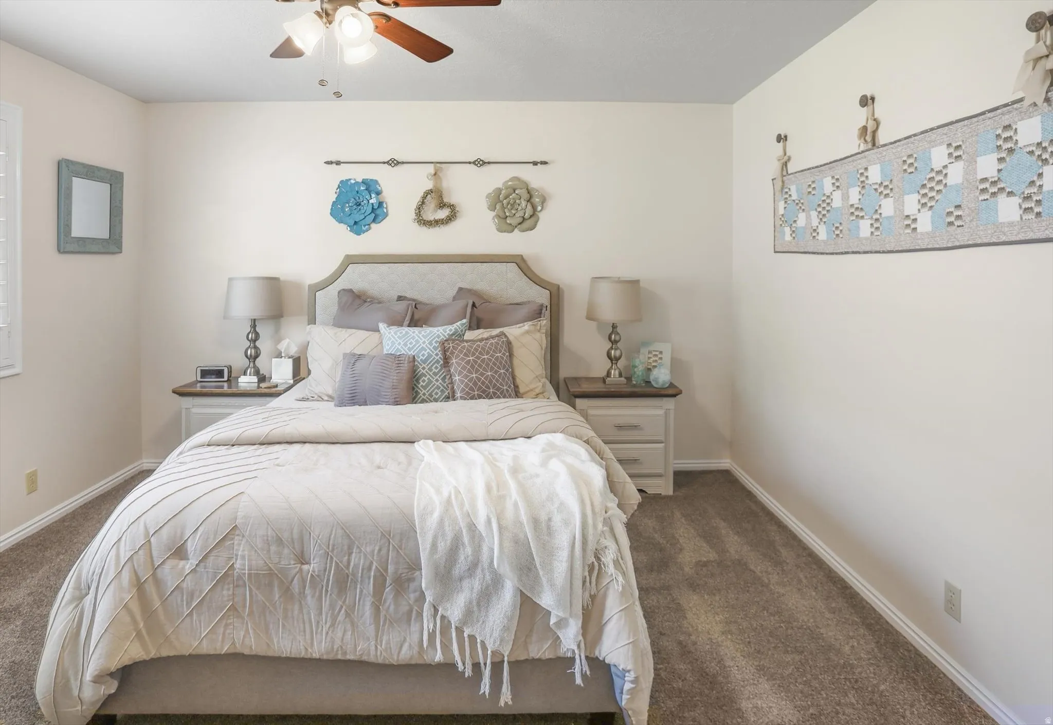 Carpeted room featuring a ceiling fan with light fixture, window with white plantation shutters, and light-colored walls