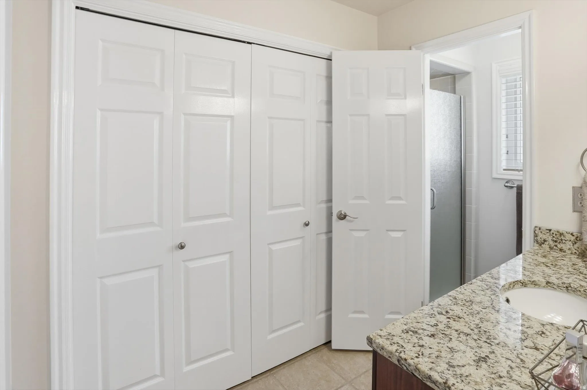 White paneled bifold closet doors with satin nickel hardware