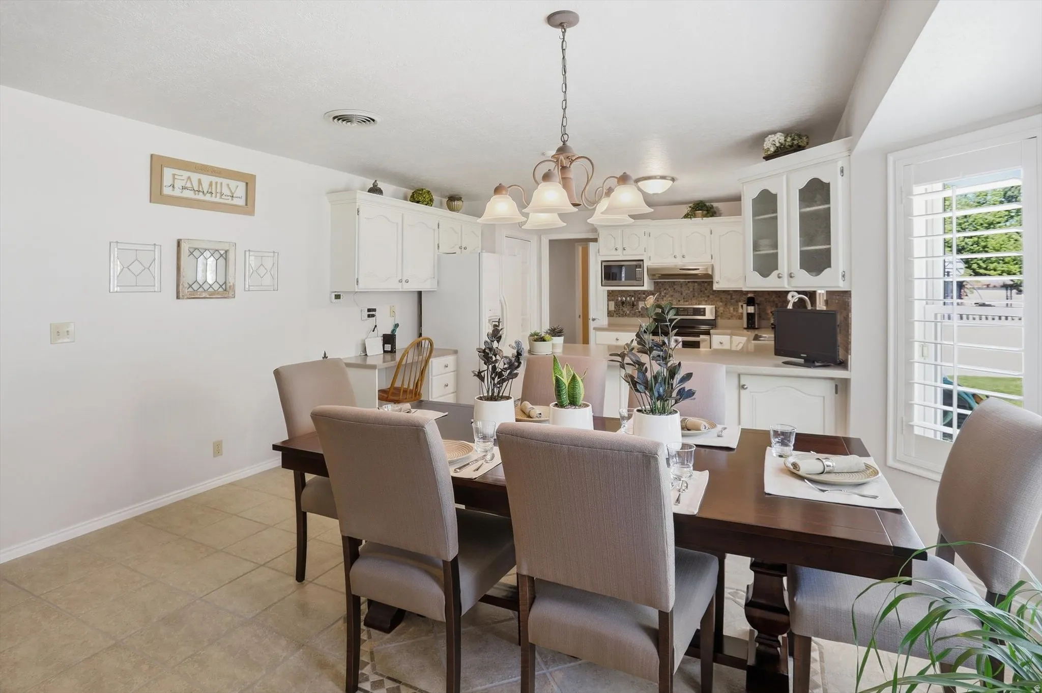 Kitchen and dining area featuring white cabinetry, a tiled backsplash, and recessed lighting