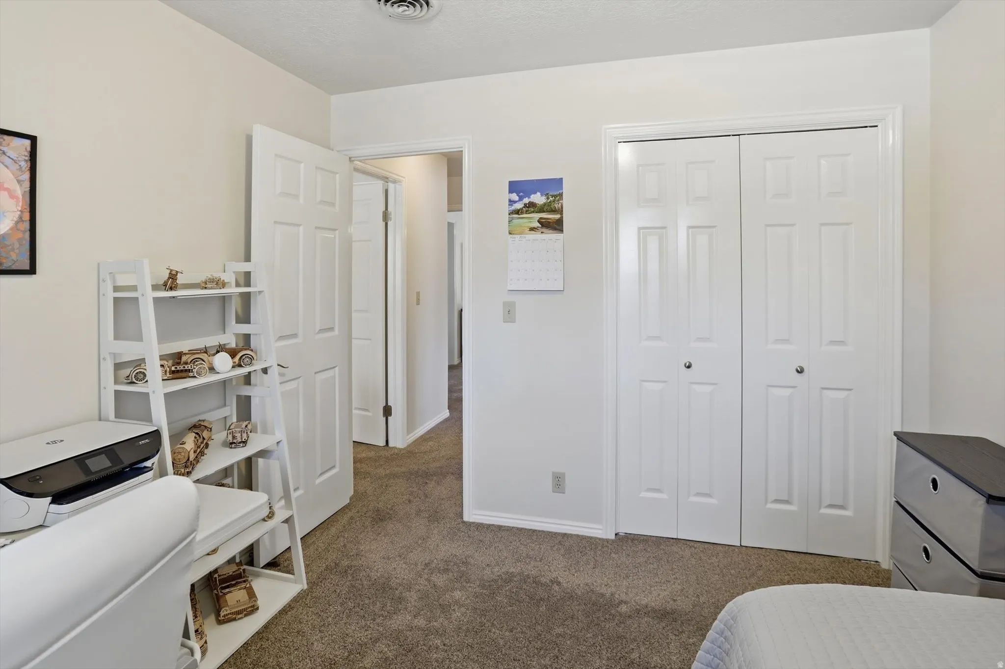 Neutral-toned interior with light tan walls, complementing brown-toned carpeting, and white trim