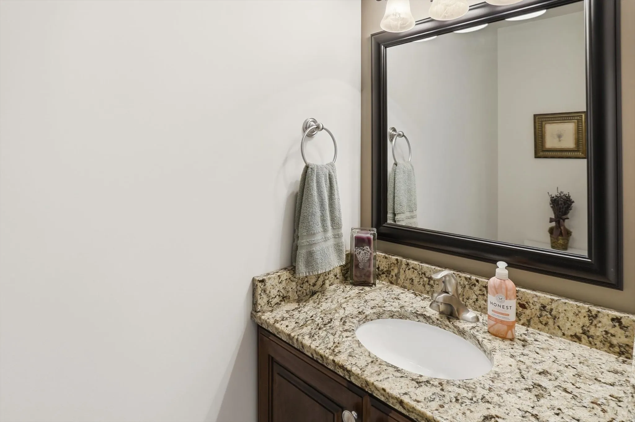 Vanity featuring a stone countertop, an undermount sink, and a dark wood-finish cabinet