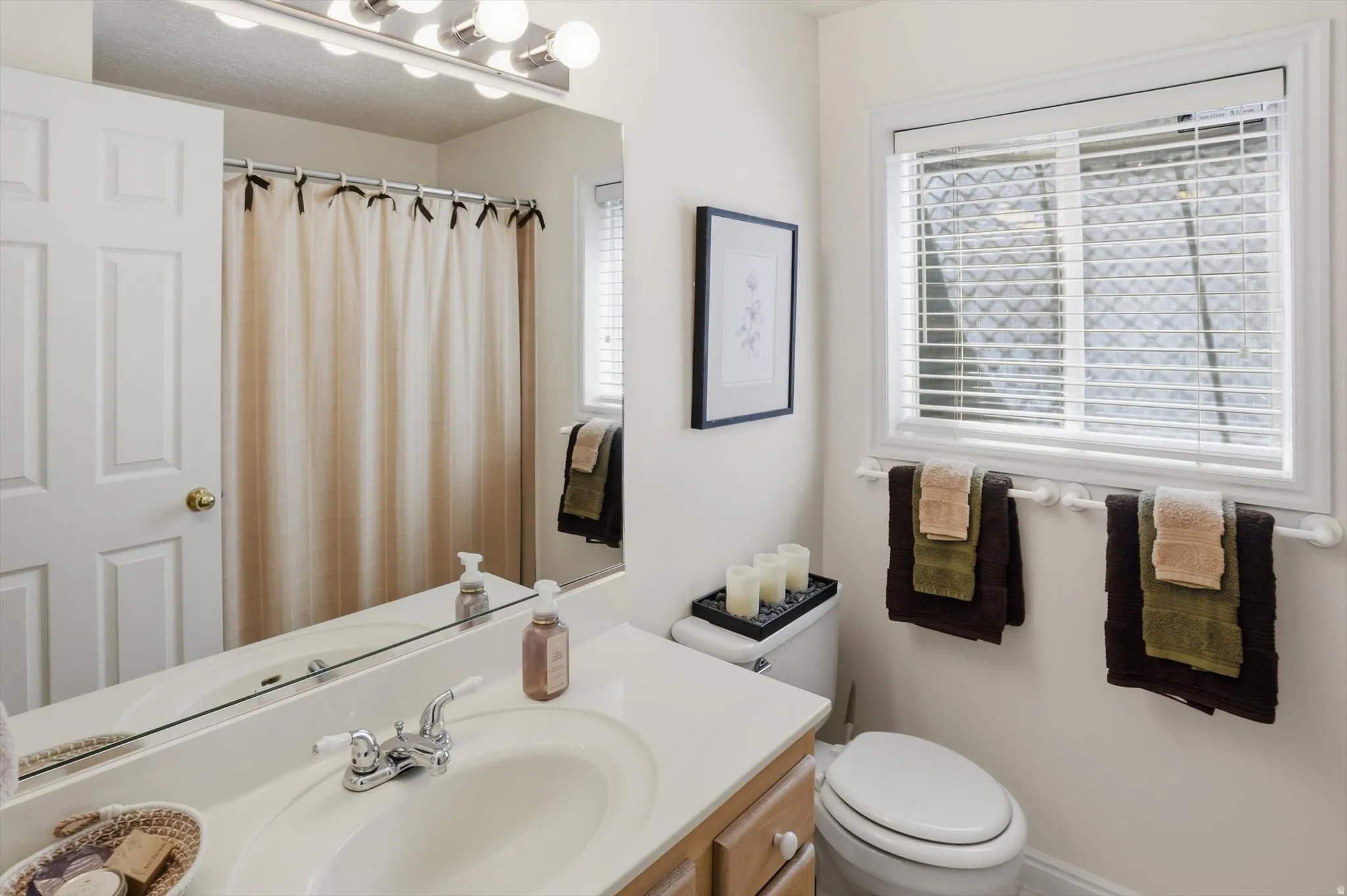 Vanity featuring an integrated sink, dual-handle faucet, and white countertop
