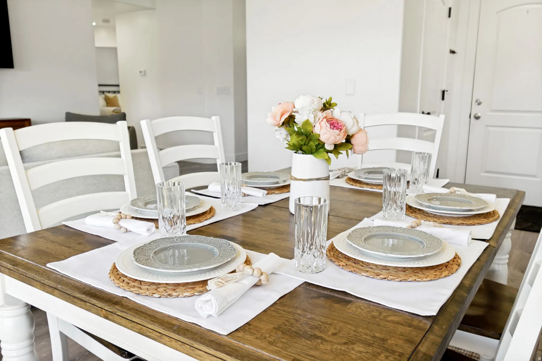 Spacious dining area featuring a wood-finish table and white chairs.