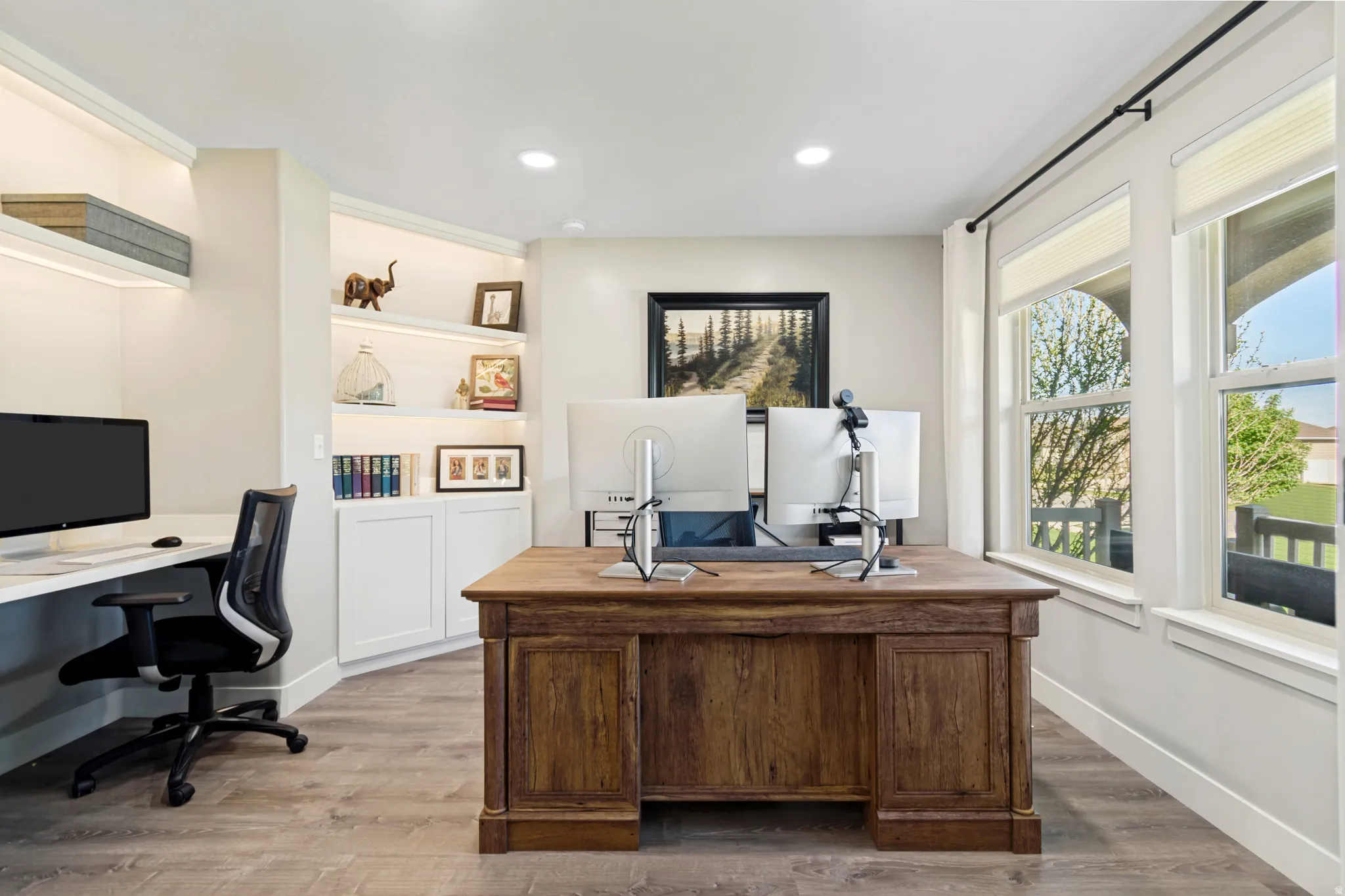 Dedicated office space featuring built-in shelving with integrated lighting.