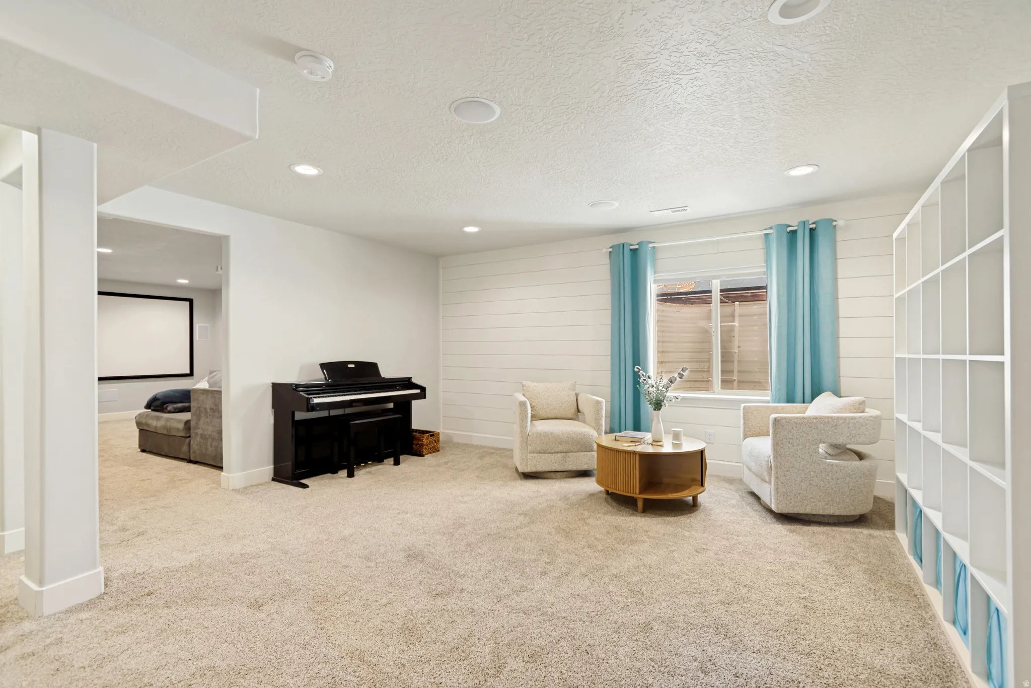 Spacious family room featuring recessed lighting, a built-in shelving unit, and shiplap accent wall.