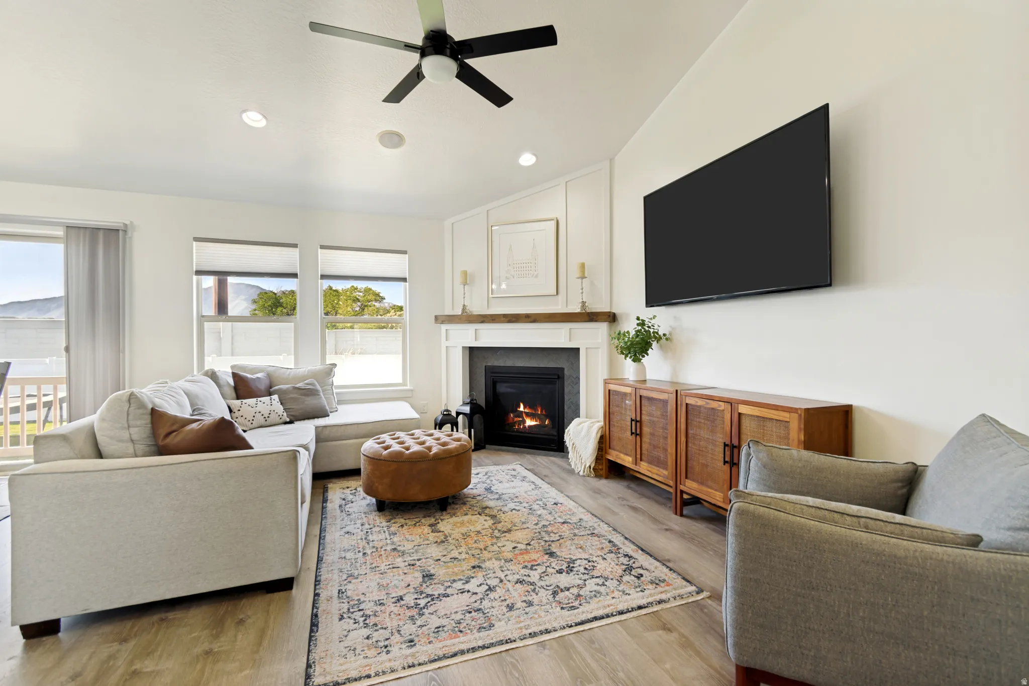 Living area featuring wood-finish flooring and a contemporary ceiling fan.