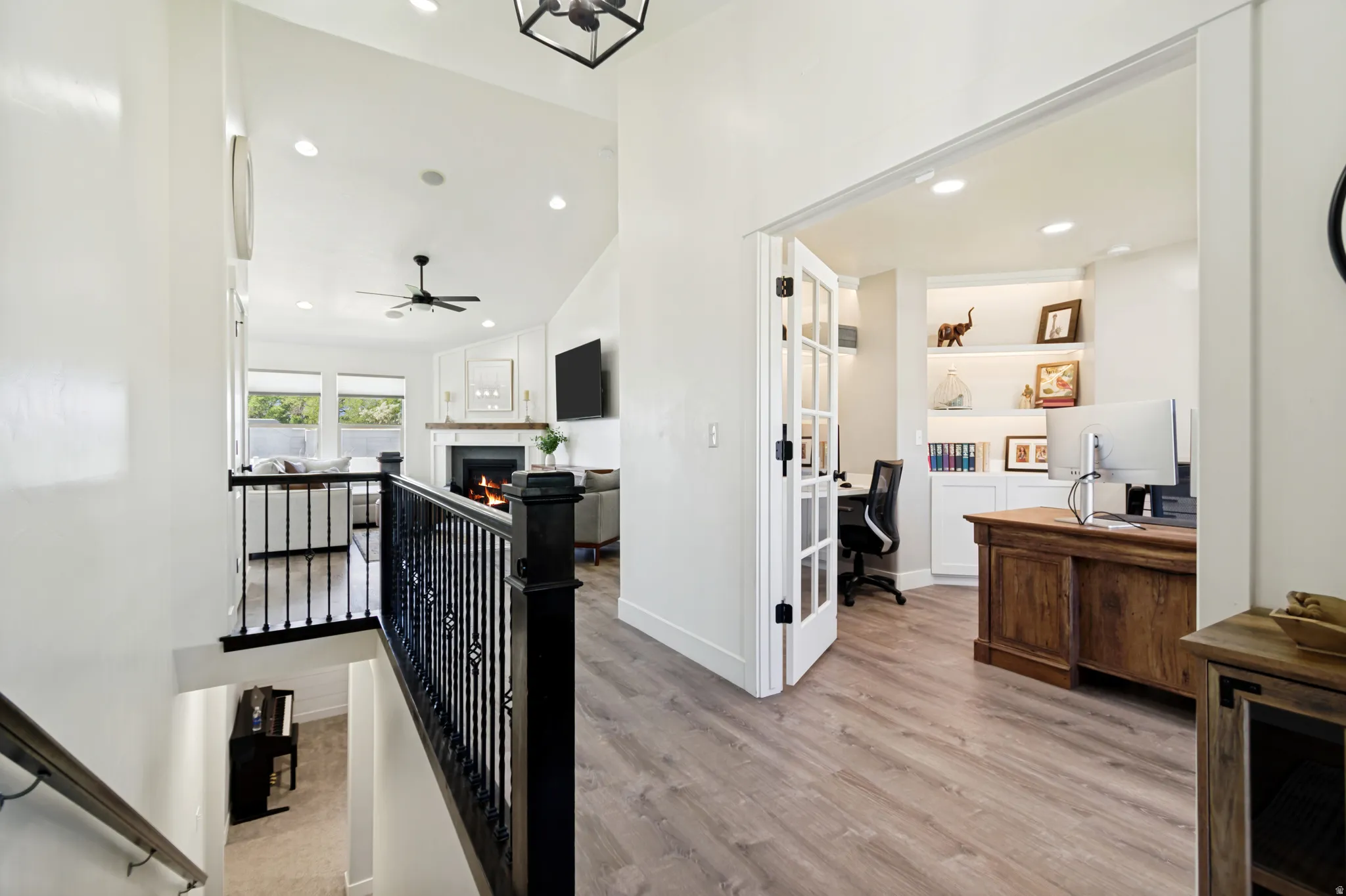 Open office space featuring French doors, recessed lighting, and built-in shelving with accent lighting.
