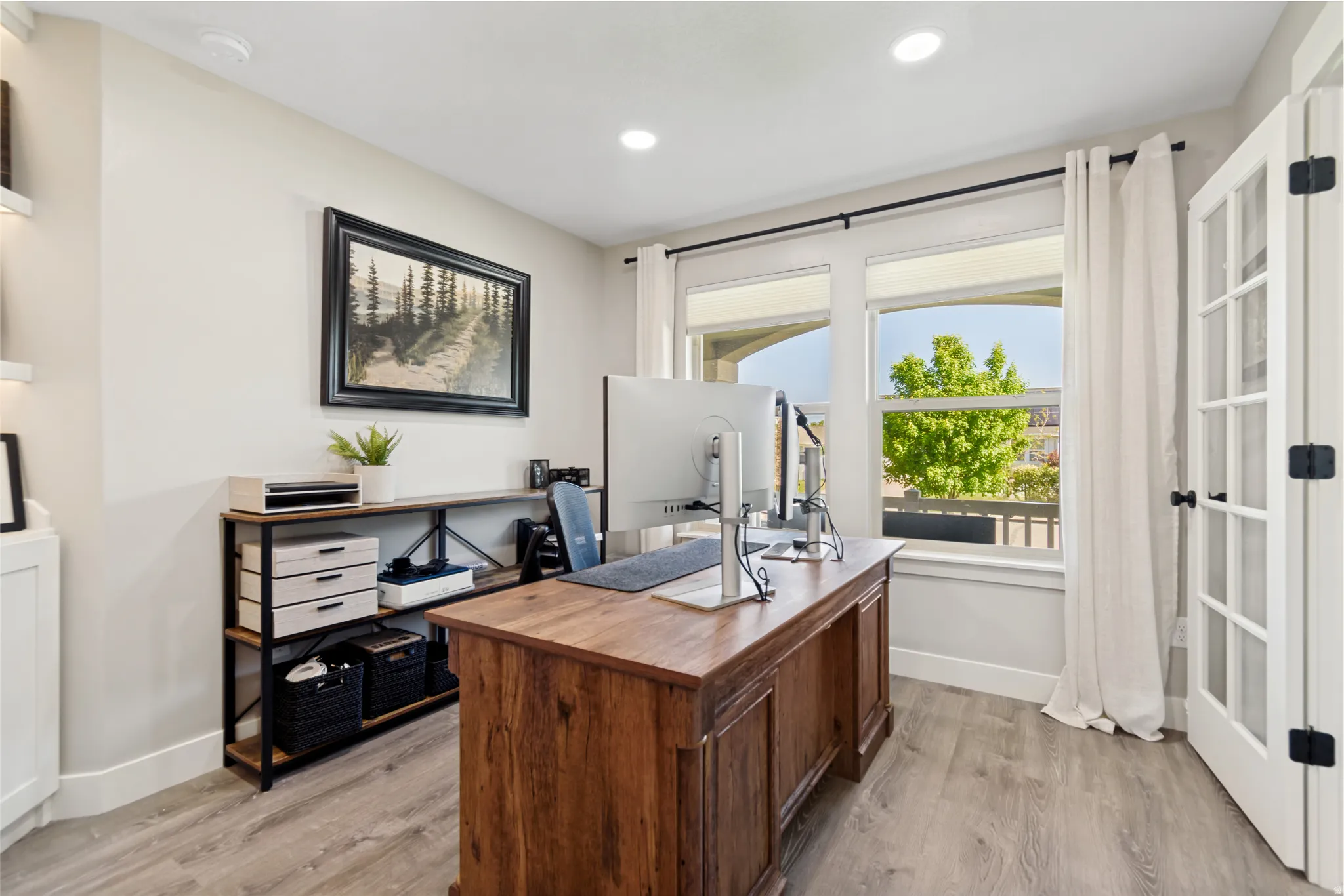 Light-filled room featuring wood-finish flooring, recessed lighting, and a large window with natural lighting.