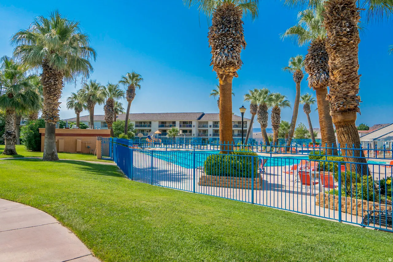 Community swimming pool with a surrounding blue metal fence