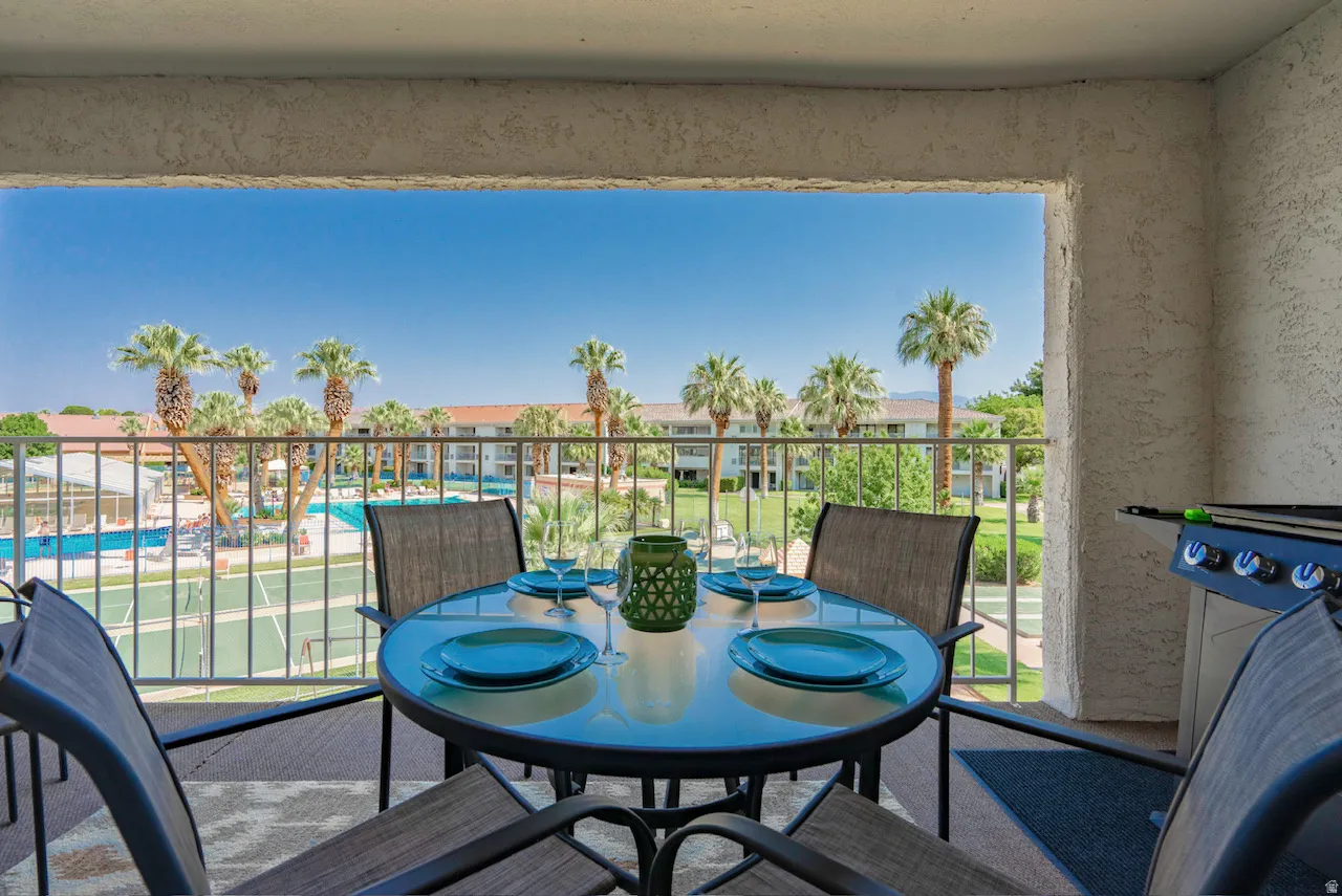 Covered balcony featuring a built-in gas grill, textured exterior walls, and a metal railing