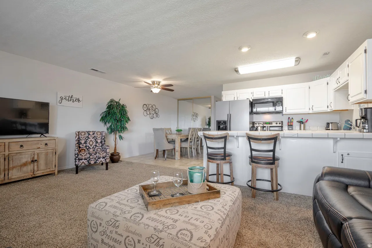 Open-concept living space featuring carpeted flooring and white walls