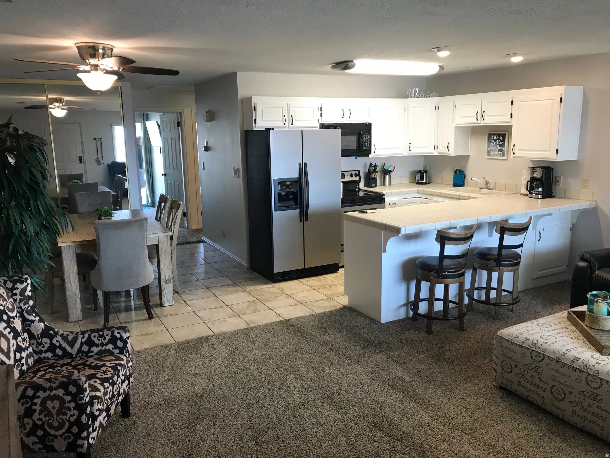 Kitchen featuring white cabinetry, tile countertops, and stainless steel appliances