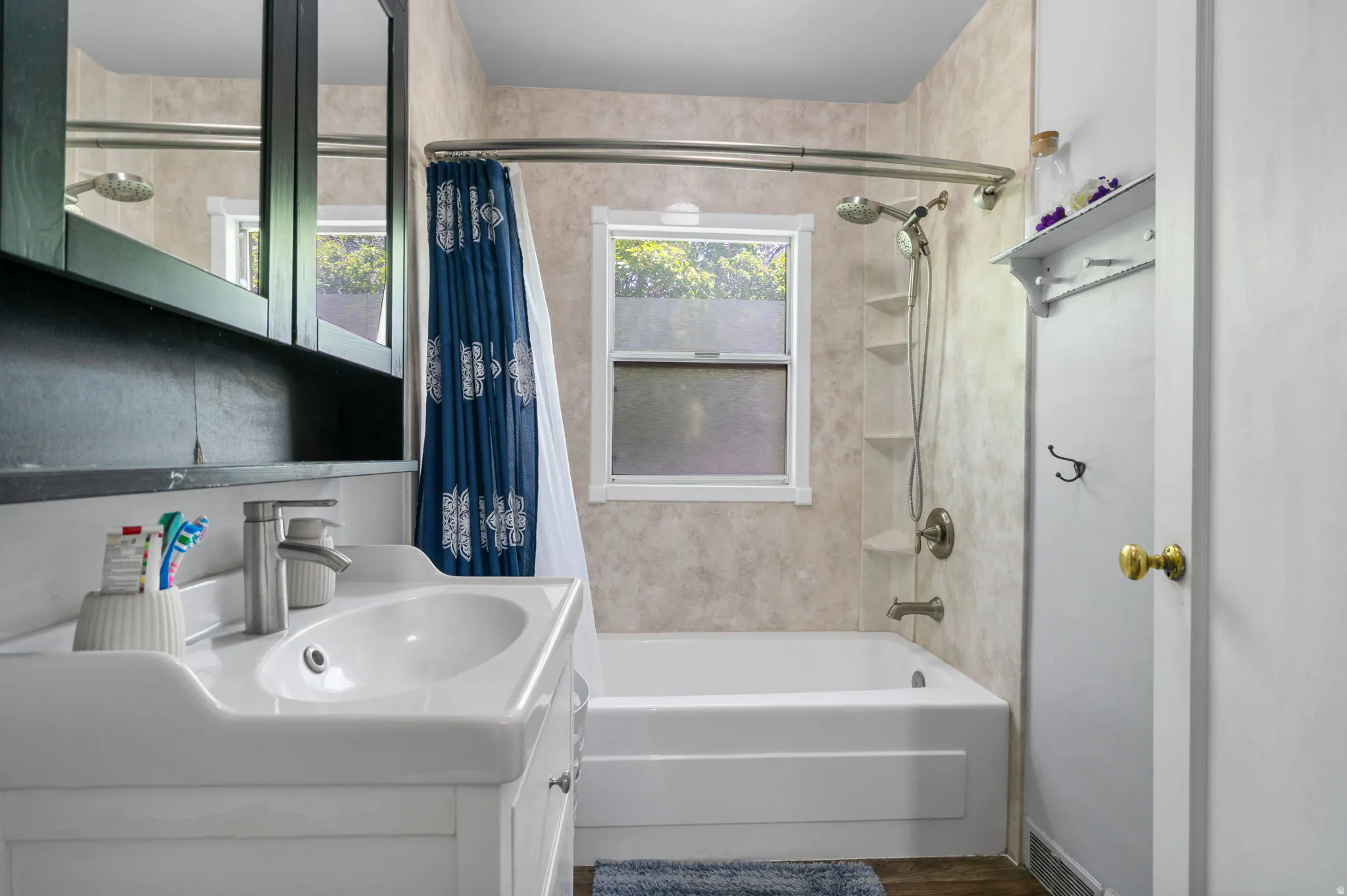 Bathroom featuring a white vanity with an integrated sink, brushed nickel faucet, and dark wood-finish medicine cabinet