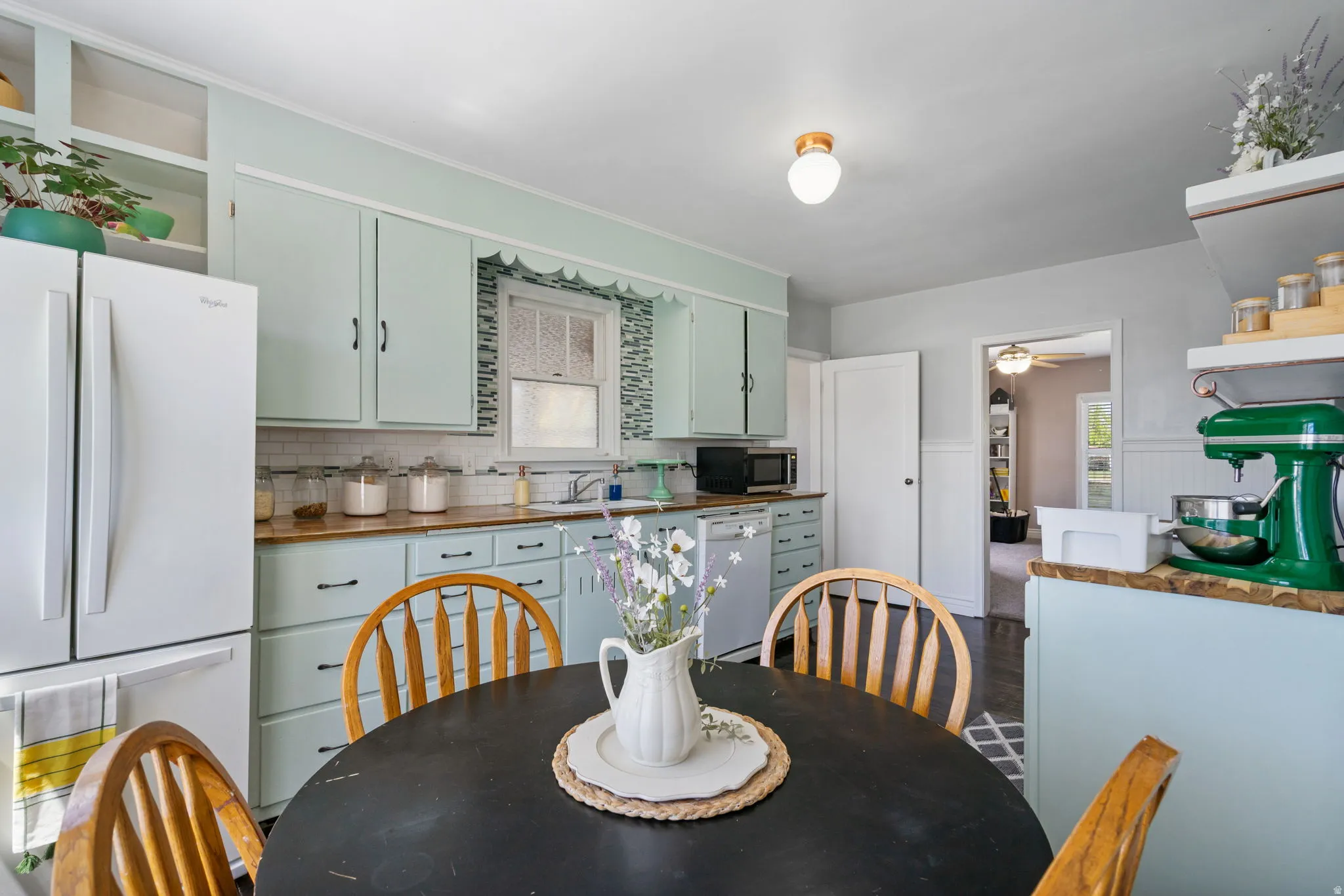 Kitchen featuring light blue cabinetry, butcher block style countertops, and a white subway tile backsplash